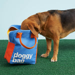 A dog taking a good look inside the Fluf organic cotton zippered doggy bag design lunch bag. The dog has his nose in the bag