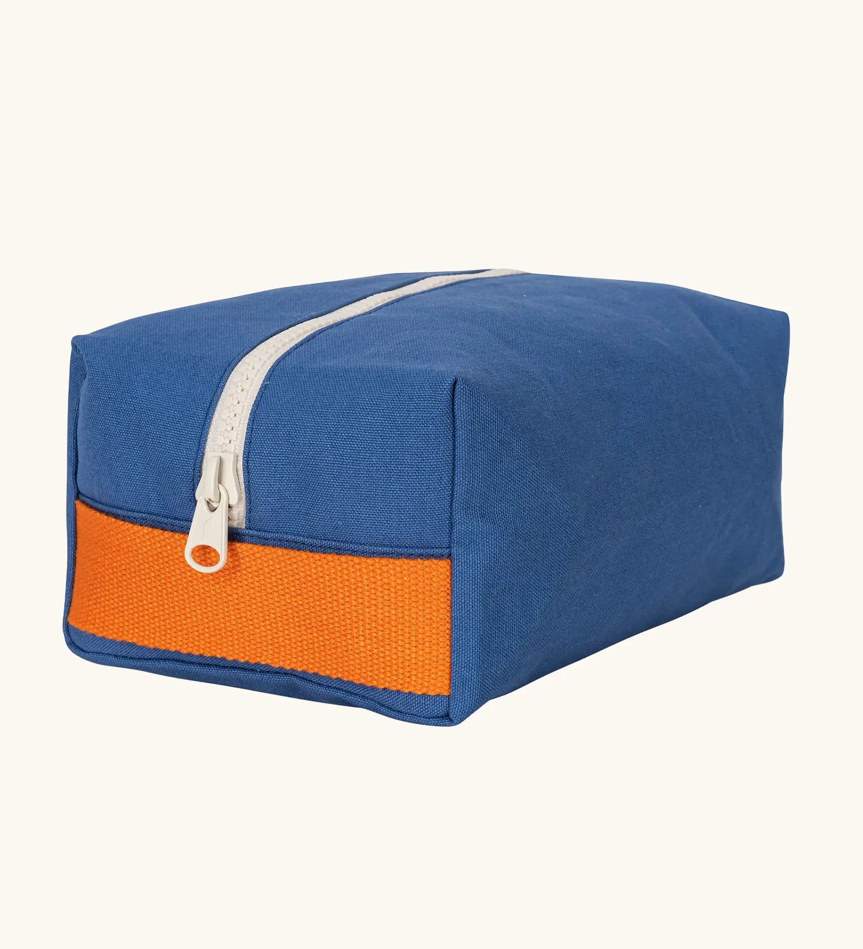 Fluf Traveller Bag in cobalt blue, a compact organic cotton washbag with orange carry handle and zip.