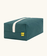 Back of the Fluf Traveller Bag in cypress green, a compact organic cotton washbag with white carry handle and zip.