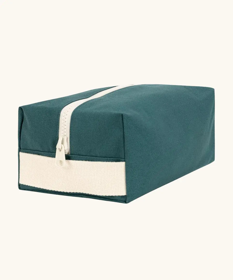 Fluf Traveller Bag in cypress green, a compact organic cotton washbag with white carry handle and zip.