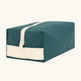 Fluf Traveller Bag in cypress green, a compact organic cotton washbag with white carry handle and zip.