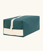Fluf Traveller Bag in cypress green, a compact organic cotton washbag with white carry handle and zip.