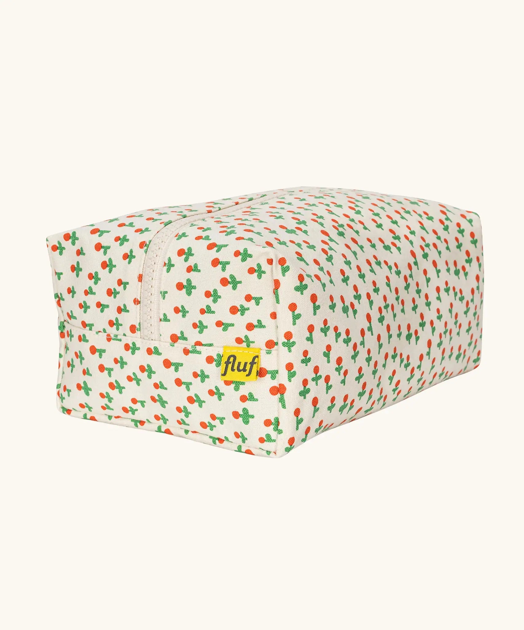 Back of Fluf Traveller Bag in tiny rose print, a compact organic cotton washbag with orange red carry handle and zip.