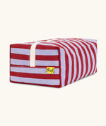 Side view of the Fluf Traveller Bag in Awning Stripe Chili Pepper, showing the striped organic cotton outer, cream zip, and Fluf label.