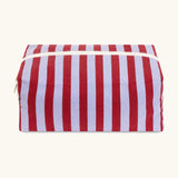 Fluf Traveller Bag in Awning Stripe Chili Pepper, the organic cotton washbag is closed from the front with cream zip and striped fabric.