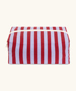 Fluf Traveller Bag in Awning Stripe Chili Pepper, the organic cotton washbag is closed from the front with cream zip and striped fabric.