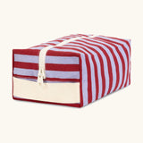 Angled front view of the Fluf Traveller Bag in Awning Stripe Chili Pepper, a compact organic cotton washbag with cream carry handle and zip.