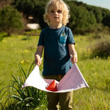 Child holding a fabric sling from the Flup throwing game with the soft throwing bag balanced on it.