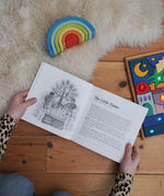 For The Children Of The World children's book by Louise deForest showing the Steiner Waldorf story pages shown open in an adult's hands in the Babipur playroom. Grimm's wooden Babi Gwawr rainbow and sparkling orient set placed on the floor.