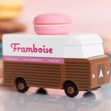 Picture of the Framboise Candylab Candyvan. It is a 1960s style brown and white van with a pink Raspberry Macaron on the roof.