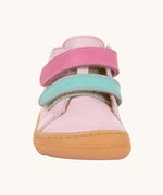 A front on view of the Froddo first step shoes in pink available at Babipur. A soft ankle high natural leather shoe in light pink with 2 velcro straps on the front in dark pink and light blue. Features a light brown rubber grippy sole and a padded ankle support.