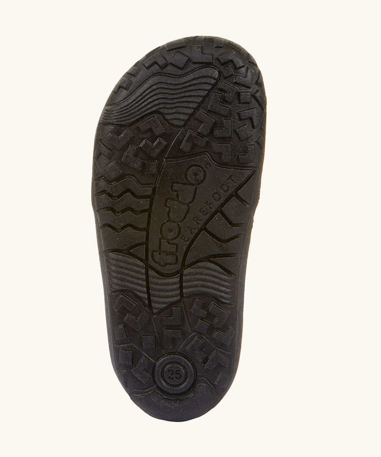 The black barefoot rubber sole of the Froddo Barefoot TEX Kids Autumn Shoes in Black. A soft ankle high shoe in black with a barefoot black rubber sole. Features two velcro straps for a secure fit.  We have a range of children's barefoot shoes available at Babipur. 
