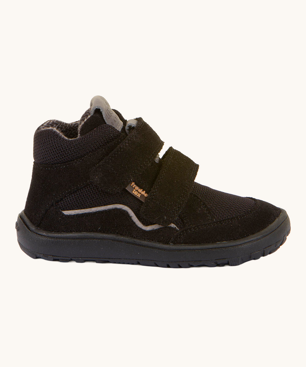 The side of the Froddo Barefoot TEX Kids Autumn Shoes in Black. A soft ankle high shoe in black with a barefoot black rubber sole. Features two velcro straps for a secure fit.  We have a range of children's barefoot shoes available at Babipur. 