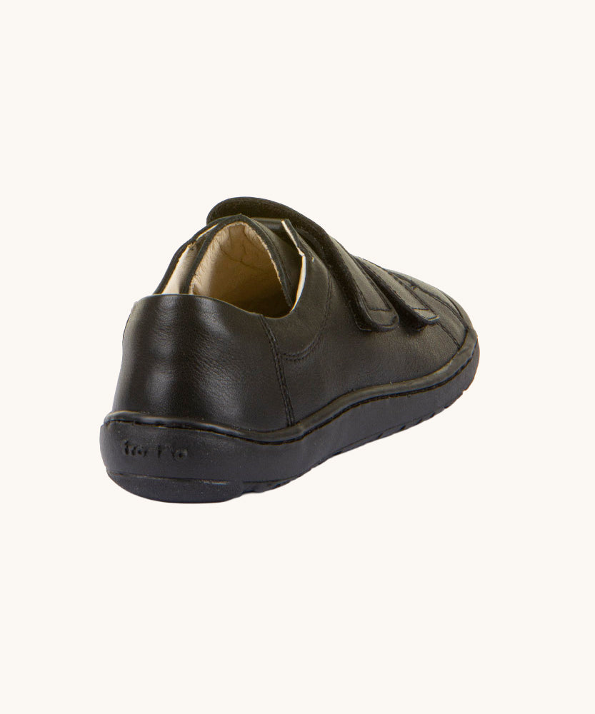 A view of the back of the Froddo Barefoot Black Alex Kids Leather School Shoes. A black leather child's school shoe with two velcro strap fastenings with a barefoot sole. We have a range of children's barefoot shoes available at Babipur. 