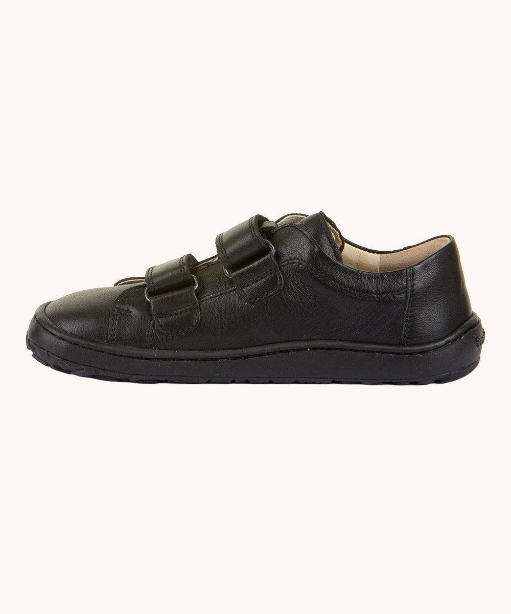 A side view of the Froddo Barefoot Black Alex Kids Leather School Shoes. A black leather child's school shoe with two velcro strap fastenings with a barefoot sole. We have a range of children's barefoot shoes available at Babipur. 