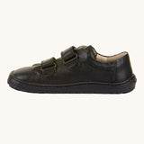 A side view of the Froddo Barefoot Black Alex Kids Leather School Shoes. A black leather child's school shoe with two velcro strap fastenings with a barefoot sole. We have a range of children's barefoot shoes available at Babipur. 