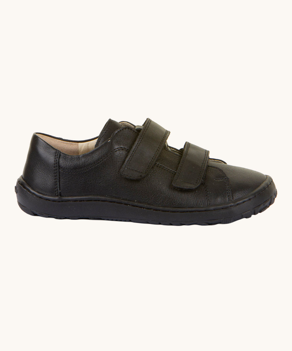A side view of the Froddo Barefoot Black Alex Kids Leather School Shoes. A black leather child's school shoe with two velcro strap fastenings with a barefoot sole. We have a range of children's barefoot shoes available at Babipur. 