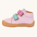 A side profile view of the Froddo first step shoes in pink available at Babipur. A soft ankle high natural leather shoe in light pink with 2 velcro straps on the front in dark pink and light blue. Features a light brown rubber grippy sole and a padded ankle support.