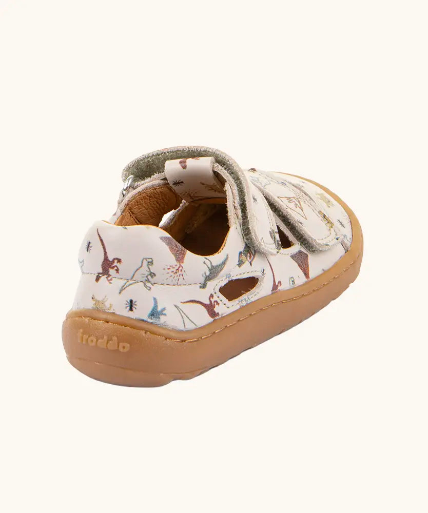Back of the Froddo barefoot kids sandals in beige with a dinosaur themed outline print.