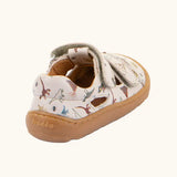 Back of the Froddo barefoot kids sandals in beige with a dinosaur themed outline print.