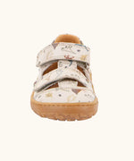 Front of the Froddo barefoot kids sandals in beige with a dinosaur themed outline print.
