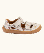 Side of the Froddo barefoot kids sandals in beige with a dinosaur themed outline print.