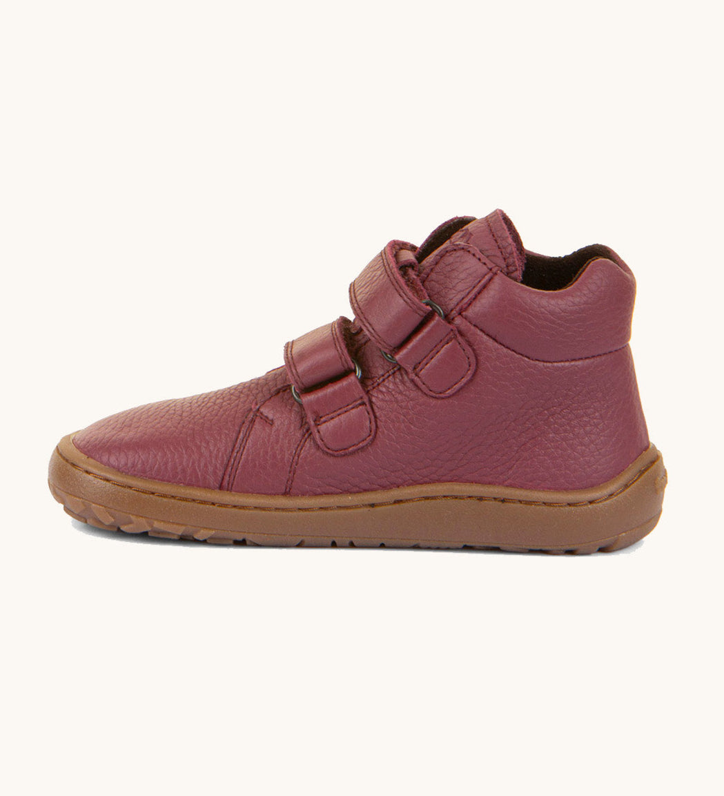 A side image of a Froddo barefoot Autumn children's shoe in bordeaux available at Babipur. A dark purple shoe showing the 2 velcro fastener for a secure fit, padded ankle and the dark brown grippy sole