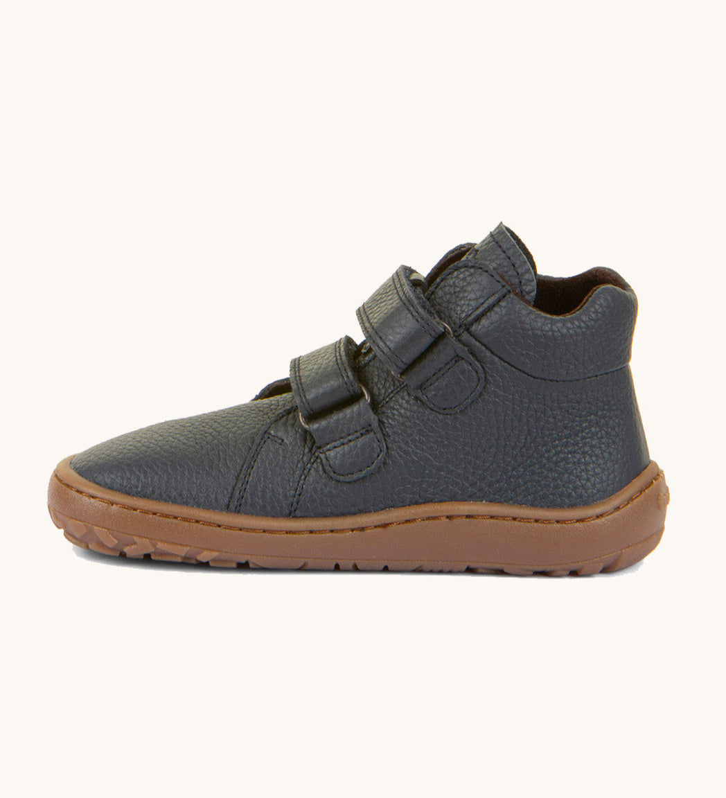 A side image of a Froddo barefoot Autumn children's shoe in dark blue available at Babipur showing the 2 velcro fastener for a secure fit, padded ankle and the dark brown grippy sole