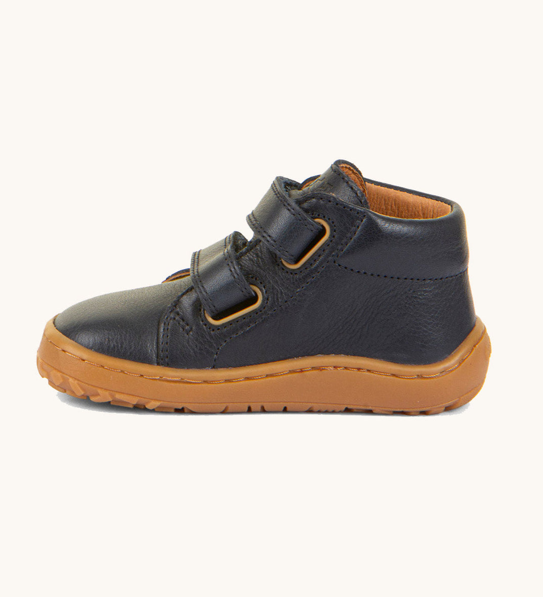 A side image of the Froddo barefoot first step baby shoe in dark blue available at Babipur showing the 2 velcro fastener for a secure fit and the grippy sole detail