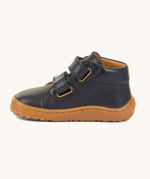 A side image of the Froddo barefoot first step baby shoe in dark blue available at Babipur showing the 2 velcro fastener for a secure fit and the grippy sole detail