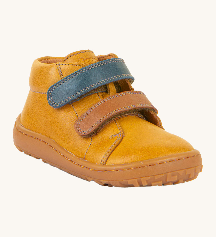 Froddo barefoot first step baby shoe in mustard. A dark yellow natural leather shoe with a 2 velcro fastener for a secure fit in blue and brown and a grippy sole