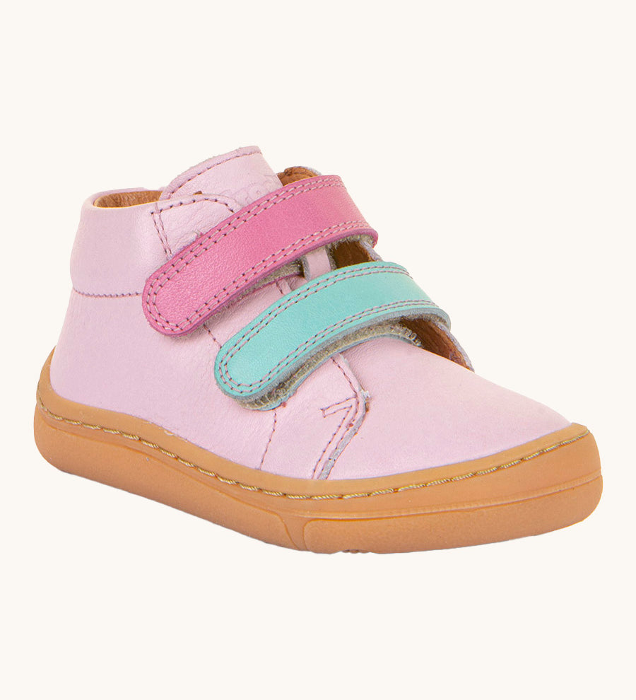 Froddo first step shoes in pink available at Babipur. A soft ankle high natural leather shoe in light pink with 2 velcro straps on the front in dark pink and light blue. Features a light brown rubber grippy sole and a padded ankle support