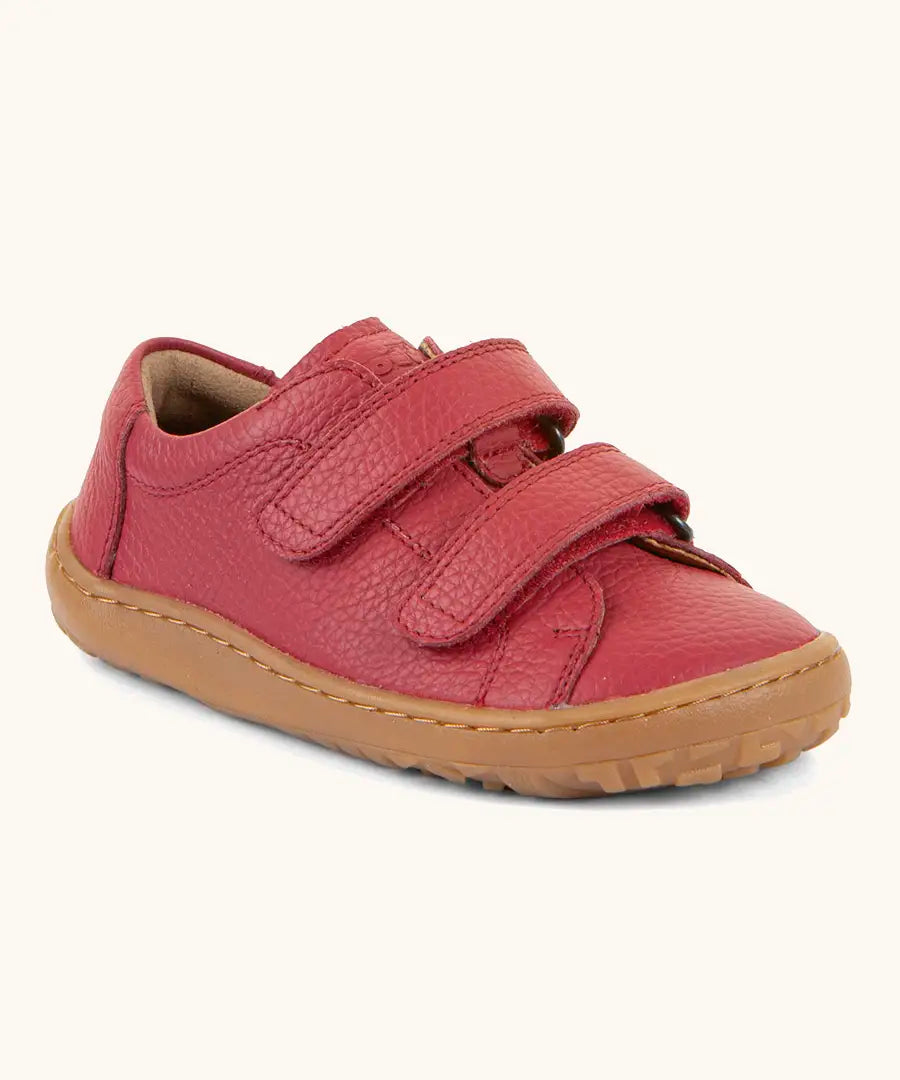 Froddo barefoot base children's shoe in red. A natural leather low profile shoe showing 2 velcro fasteners and a grippy sole