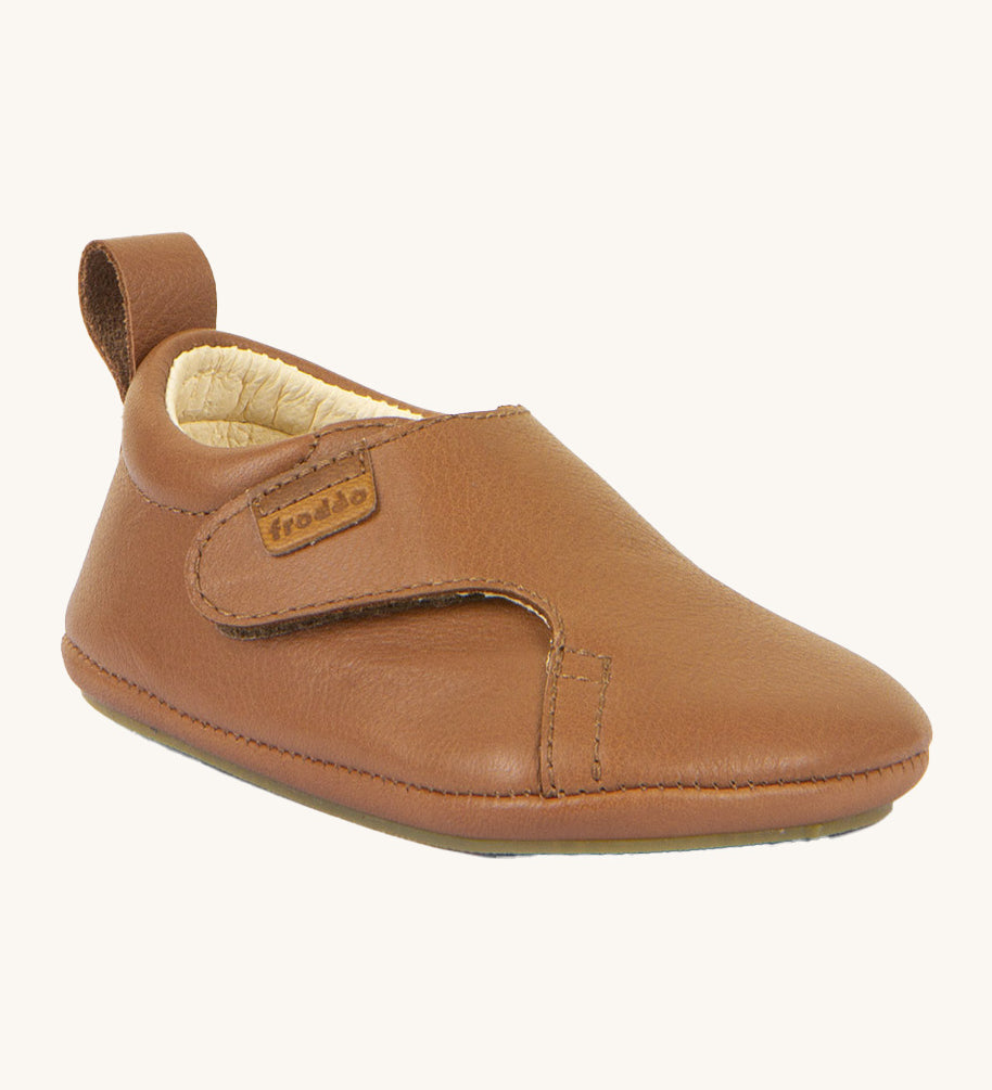 Froddo barefoot walker baby shoe in cognac. A light brown natural leather shoe with a pull tab on the back for easy fitting, a velcro fastener and a grippy sole