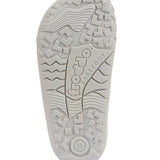 detail of the froddo barefoot kids sole in white. Grippy knobbly areas and the word barefoot etched into the sole. 