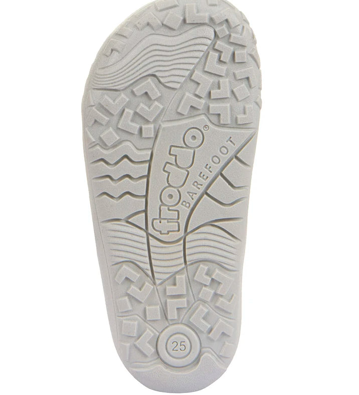 detail of the froddo barefoot kids sole in white. Grippy knobbly areas and the word barefoot etched into the sole. 