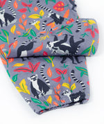 Close up of the Frugi Rowenna outfit, lemur laugh showing the printed lemurs next to different coloured leaves and leg cuff details on the bottoms  on light purple organic cotton fabric