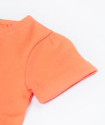 Close up of the Frugi Rowenna outfit, lemur laugh. Showing the sleeve detail on the coral t-shirt on organic cotton fabric