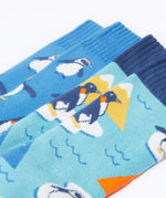 A close up of the Frugi 2 pack penguin brilliant boot socks showing the print detail on blue organic cotton fabric