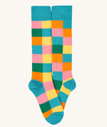 A close up of the rainbow Frugi brilliant boot sock showing the multicoloured check print with light blue toe and heel detail organic cotton fabric