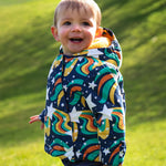 A child wearing the coat from the Frugi 2 in 1 rambler pram suit to coat in magic stars. A thick warm hooded coat with a yellow fleece inner for warmth 