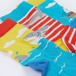 A close up of Frugi Rock My Socks 3 Pack, in the High Seas print. Featuring a bright striped pair, a blue pirate ship pair, and a brilliant shark pair.
