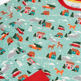 Close up of the print details on the Frugi adults organic cotton perranporth pyjamas with a festive winter drives print on a light moss green background. 