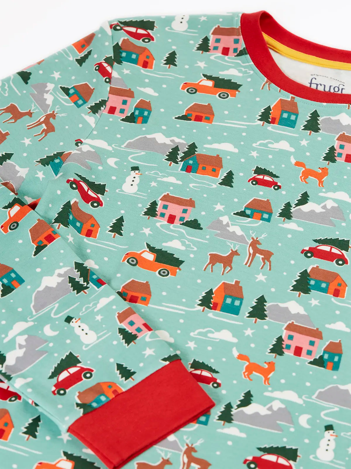 Close up of the print details on the Frugi adults organic cotton perranporth pyjamas with a festive winter drives print on a light moss green background. 