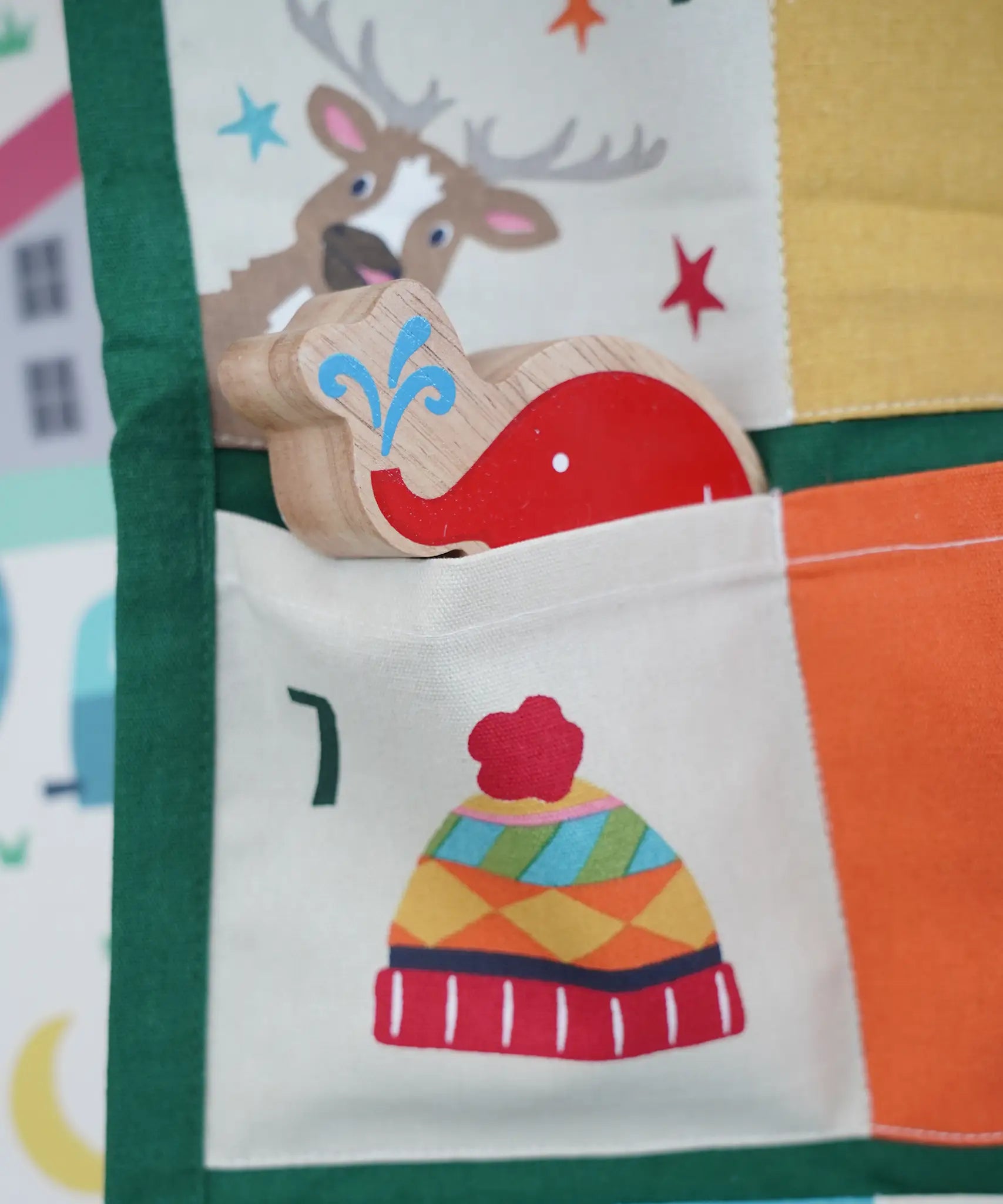 Close up of a Babipur elephant Lnaka Kade figure placed into one of the pockets on the Frugi forest festive fun organic cotton advent calendar.