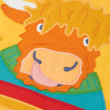 Close up of the Highland cow coo applique on the Frugi adventure circular cotton top in bumblebee yellow.