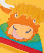 Close up of the Highland cow coo applique on the Frugi adventure circular cotton top in bumblebee yellow.
