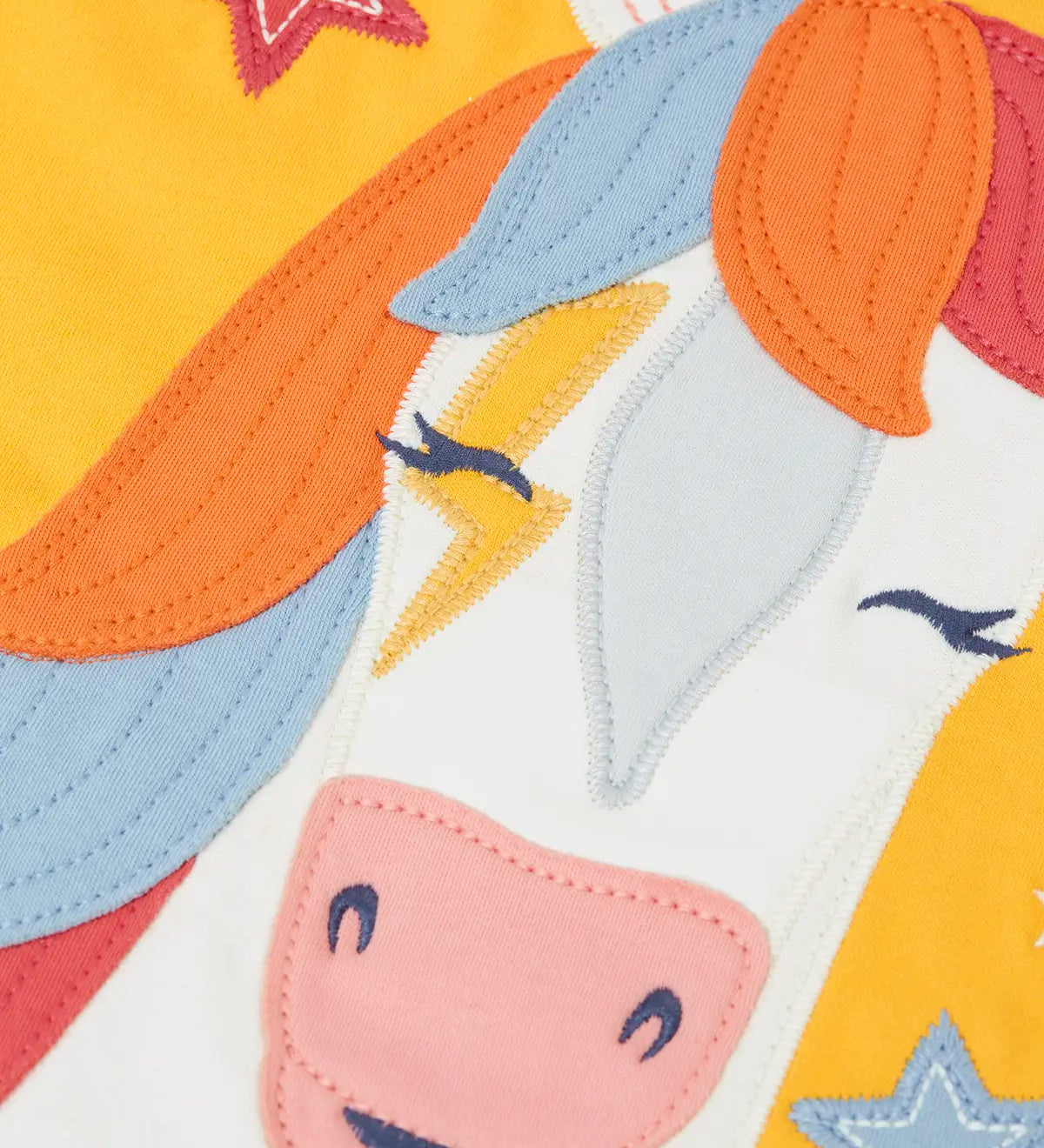 Zoomed in view of the horse applique on the font of the Frugi adventure circular organic cotton long sleeve top in bumblebee yellow.