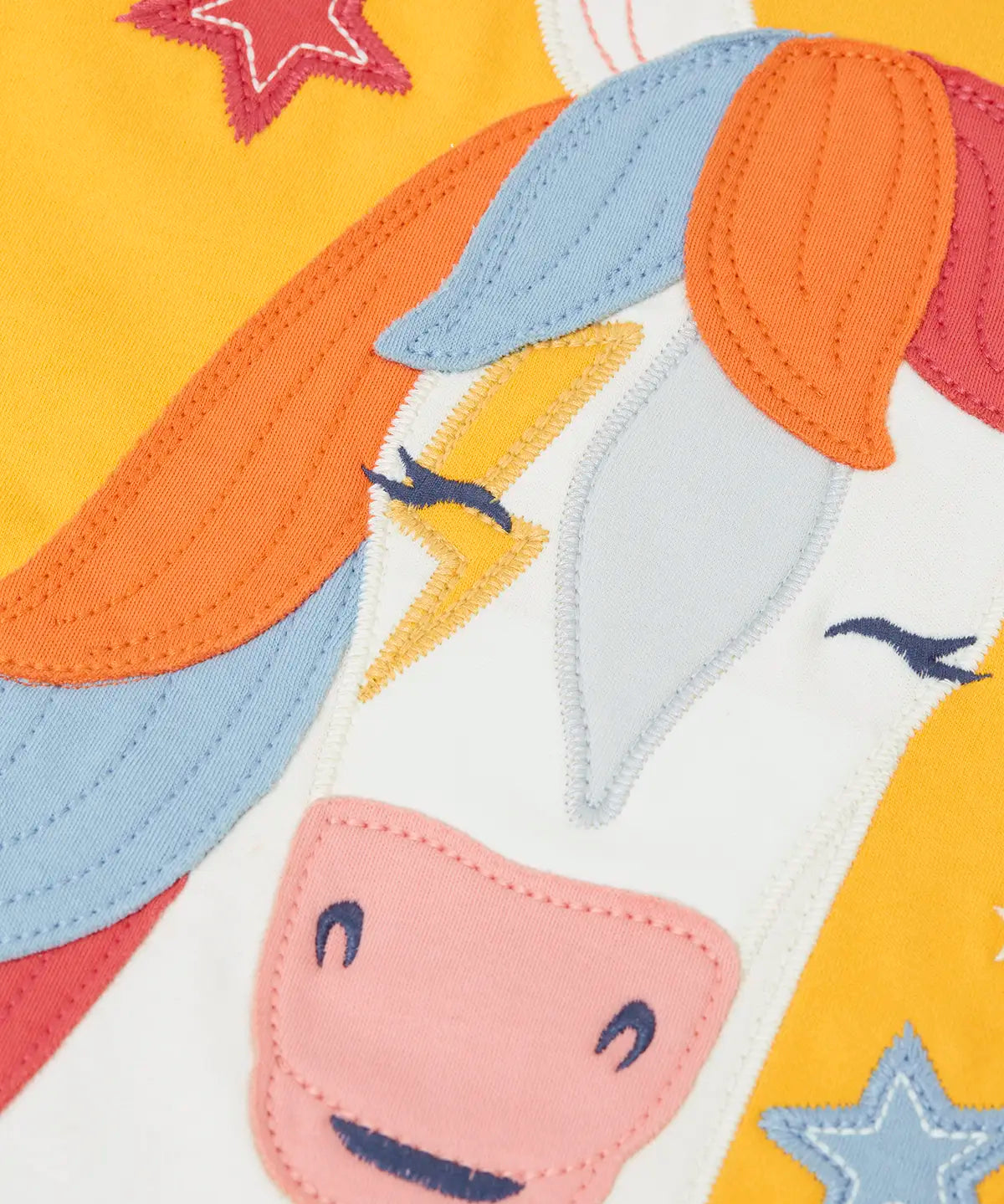 Zoomed in view of the horse applique on the font of the Frugi adventure circular organic cotton long sleeve top in bumblebee yellow.