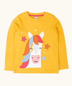 Frugi adventure circular organic cotton long sleeve top in bumblebee yellow with a white horse applique with a rainbow mane on the front surrounded by stars. 